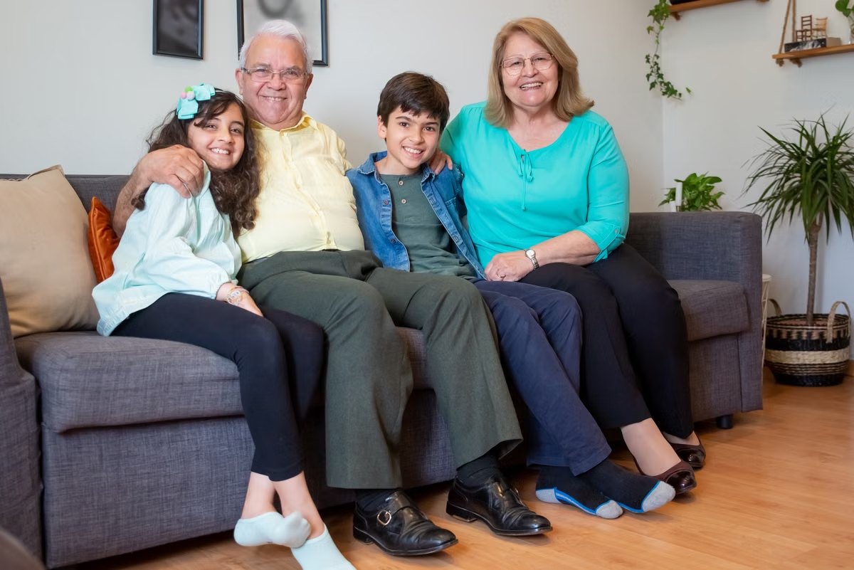 Three generations of a family together on the sofa at home